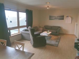 ein Wohnzimmer mit einem Sofa und einem Tisch in der Unterkunft Kristian 4. Gt. apartement in Vardø
