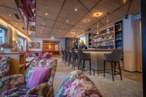 a bar in a restaurant with chairs and a bar counter at Der Rindererhof in Tux