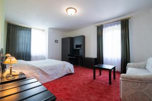 une chambre d'hôtel avec un lit et un canapé dans l'établissement Villa Kalman Pansio, à Dunabogdány