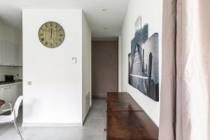 a hallway with a clock on the wall and a table at Prestige Apartments - spacious flats with terraces in Lugano