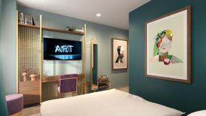 a bedroom with a bed and a tv on a wall at Marmont Hotel in Geneva