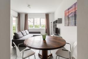 un soggiorno con tavolo e divano di Prestige Apartments by Quokka 360 - spacious flats with terraces a Lugano
