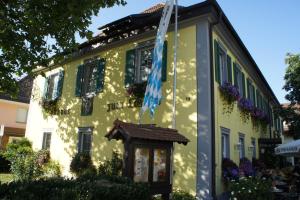 a yellow house with a flag in front of it at Hotel und Wirtshaus Löwen in Rielasingen-Worblingen