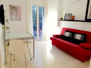 sala de estar con sofá rojo y mesa en Enric Granados 15, en Barcelona