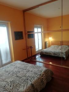 ローマにあるCasa di Marco a Trastevereのベッド2台と大きな鏡のある寝室