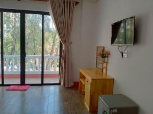a living room with a television and a large window at Kim Lien Phu Quoc Guesthouse in Phú Quốc