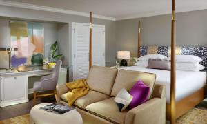a hotel room with a bed and a couch at La Playa Beach & Golf Resort, a Noble House Resort in Naples