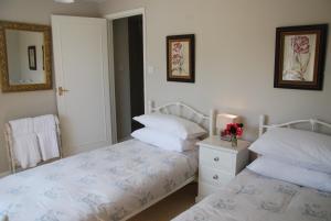 a bedroom with two beds and a mirror at Snaffles in Royal Tunbridge Wells