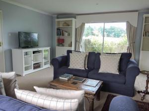 a living room with a blue couch and a table at Snaffles in Royal Tunbridge Wells