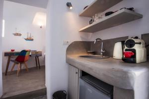 伊亞的住宿－Cupola Suites，厨房配有水槽和台面