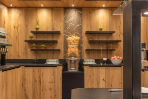 a kitchen with wooden walls and a counter with fruit on shelves at Der Rindererhof in Tux