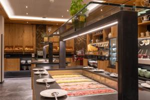 a restaurant with a counter with plates on it at Der Rindererhof in Tux