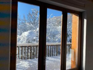 a window with a view of snow covered trees at Plein soleil in Briançon