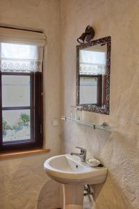 a bathroom with a sink and a mirror and a window at Beguta Guest House in Haapsalu