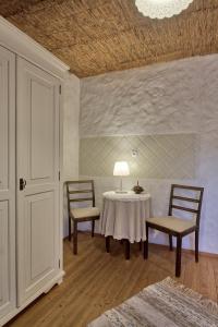 ハープサルにあるBeguta Guest Houseのテーブル、椅子2脚、ランプが備わるお部屋