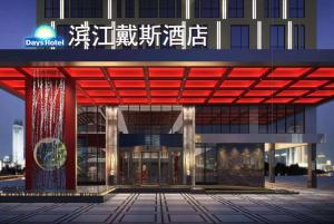 a large building with a red canopy in front of it at Days Hotel by Wyndham Binjiang Changsha in Changsha