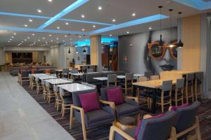 a restaurant with tables and chairs in a room at La Quinta Inn & Suites by Wyndham Lewisville in Lewisville
