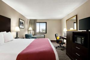 a hotel room with a bed and a flat screen tv at Baymont by Wyndham Sioux Falls North,I-29,Russell St, Airport in Sioux Falls