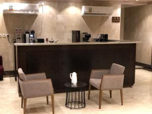 دار المأمون للشقق المفروشة في جدة: بار بثلاث كراسي وطاولة في الغرفة
