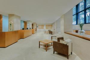 an office lobby with desks and chairs and a table at Hesperia Barcelona Del Mar in Barcelona