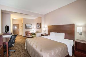 a hotel room with a large bed and a desk at Quality Inn & Suites Lawrence - University Area in Lawrence