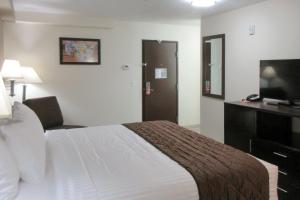 a hotel room with a bed and a flat screen tv at Econo Lodge Umatilla Columbia River Area in Umatilla