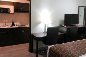 a hotel room with a desk and a bed and a sink at Econo Lodge Umatilla Columbia River Area in Umatilla