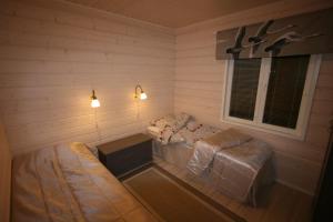um pequeno quarto com uma cama e uma janela em Ähtärin lomamökit - AARRE Mökki em Ahtari