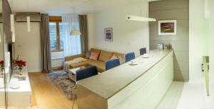 a kitchen and living room with a counter and a couch at SLAVNA - Luxe & Wine by the Fortress in Belgrade +11 photos