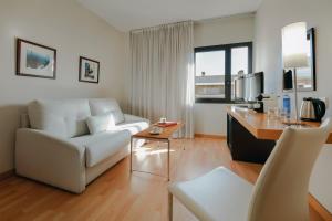 a living room with a white couch and a table at Hesperia Barcelona Del Mar in Barcelona