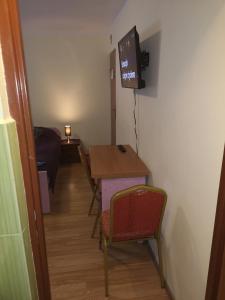 Cette petite chambre comprend une table et une télévision. dans l'établissement Agroturystyka w Dolinie Narwi, à Łomża