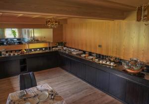 a large kitchen with a long counter and a table at Pension Pernthaler in Silandro