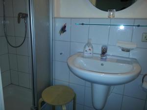 y baño blanco con lavabo y ducha. en Hotel Blaues Haus, en Otterberg