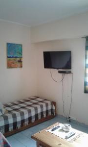Zimmer mit einem Bett und einem Flachbild-TV in der Unterkunft Departamento Centro Villa Carlos Paz in Villa Carlos Paz