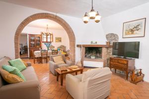 a living room with a fireplace and a tv at Villa Mealli Unifamiliare in Radicofani