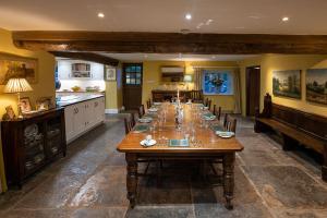 a large dining room with a long wooden table at Middle Farm House in Shepton Mallet