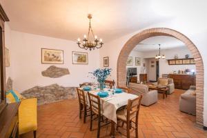 a dining room with a table and a living room at Villa Mealli Unifamiliare in Radicofani