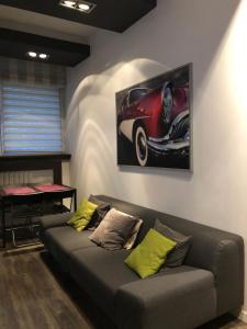 a living room with a couch and a picture of a car at Apartament Jagiellonska in Sosnowiec