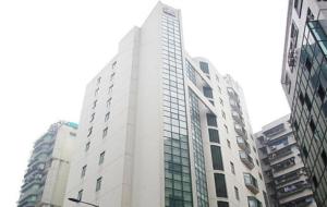 un edificio blanco alto con muchas ventanas en una ciudad en Jinjiang Inn - Chongqing Shopping & Entertainment Center en Chongqing