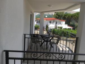 a balcony of a house with a table and chairs at Apartments More in Baška