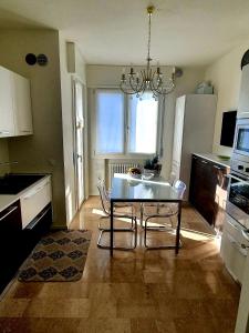 a kitchen with a table and chairs and a chandelier at Arianna Apartments in Vittorio Veneto