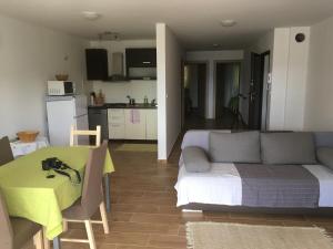 Apartments More في باشكا: غرفة معيشة مع أريكة وطاولة ومطبخ