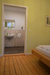 ein Bad mit einem Waschbecken und ein Bett in einem Zimmer in der Unterkunft Altstadtpension Hameln in Hameln