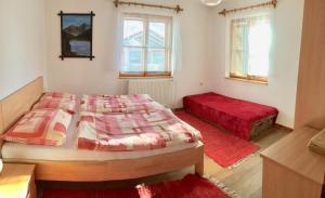 sypialnia z 2 łóżkami i czerwonym dywanem w obiekcie Chalupa Zeleznik w Zuberzcu