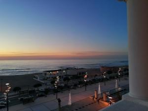 a view of the beach at sunset from a building at THE ONE Grand Hotel da Póvoa in Póvoa de Varzim