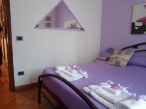 ヴェローナにあるVerona Bottego Guest Houseのベッドルーム1室(紫色のベッド1台、タオル付)