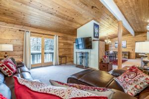 a living room with a leather couch and a television at Vance Bay Getaway in Manitowish Waters