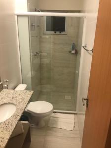 een badkamer met een toilet en een glazen douche bij Salinas Park Resort in Salinópolis