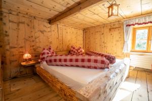 1 dormitorio con 1 cama en una cabaña de madera en Berghaus am Sonnenhang Valpaschun en Valchava