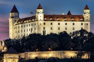 a castle on top of a hill at night at Queen Flat in Old Town with Castle view in Bratislava